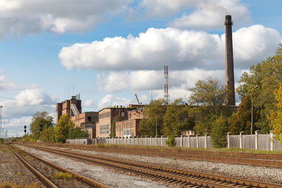 Railroad tracks by buildings against sky