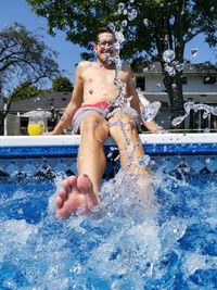 Portrait of young couple sitting on swimming pool