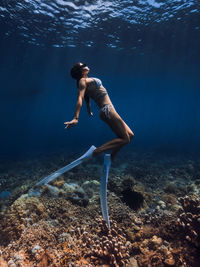 Rear view of woman swimming in sea