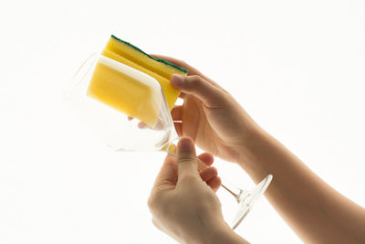 Midsection of woman holding ice cream against white background