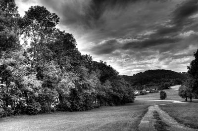 Country road against cloudy sky