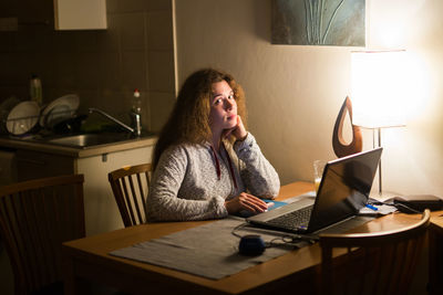 Woman sitting on table at home