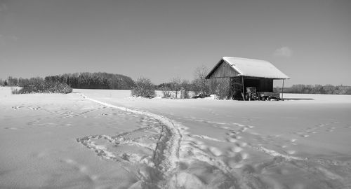 Built structure on snow covered field against sky