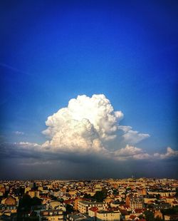Aerial view of cityscape against blue sky