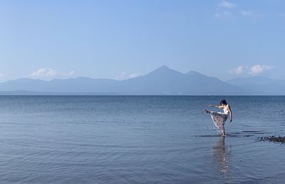 Man in sea against sky