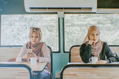 Women wearing hijab sitting at coffee shop 