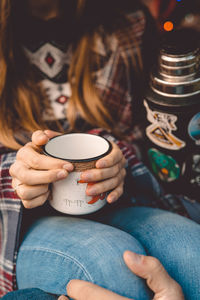 Midsection of woman drinking coffee