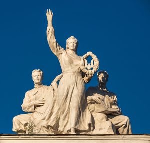 Low angle view of angel statue against clear blue sky