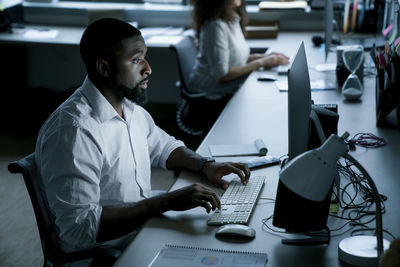 Business people working on desktop computers at desk in office