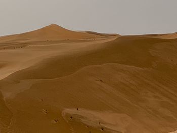 Sand dunes in desert against clear sky