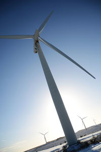 Low angle view of windmill against clear blue sky