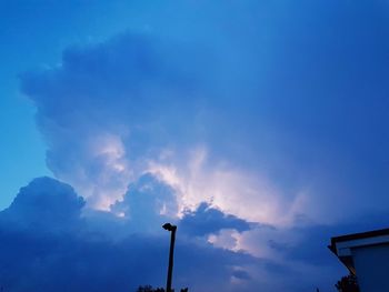 Low angle view of street light against blue sky