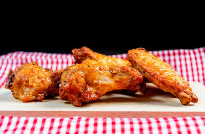 Close-up of barbecue meat on cutting board against black background