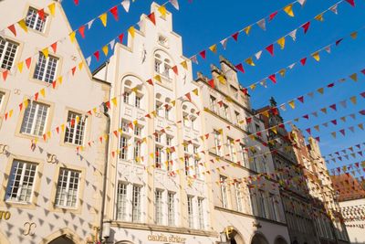 Low angle view of flags on building against sky