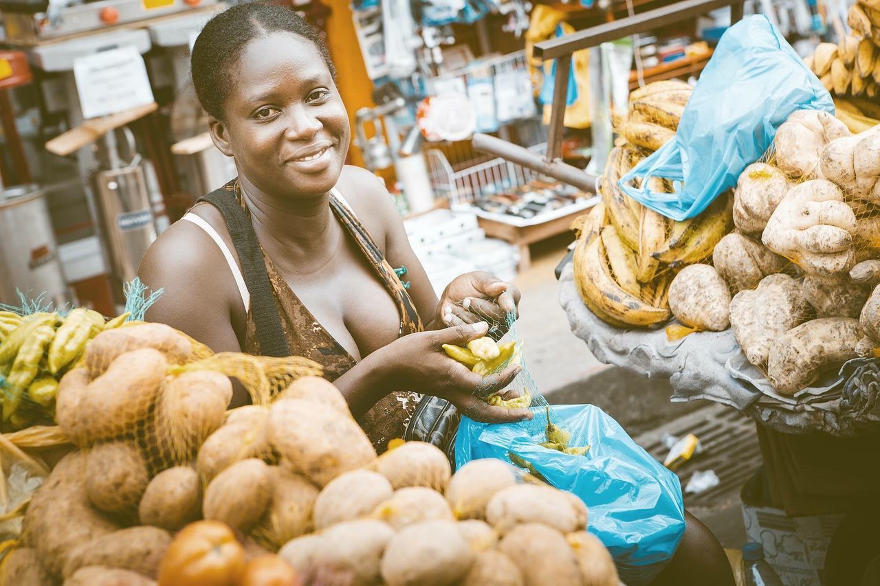 retail, food, food and drink, market, one person, market stall, smiling, freshness, vegetable, healthy eating, real people, portrait, shopping, casual clothing, holding, store, choice, large group of objects, business, outdoors, buying