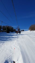 Overhead cable car on snow covered land against sky