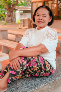 Portrait of a smiling woman sitting outdoors