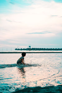 Man in sea against sky