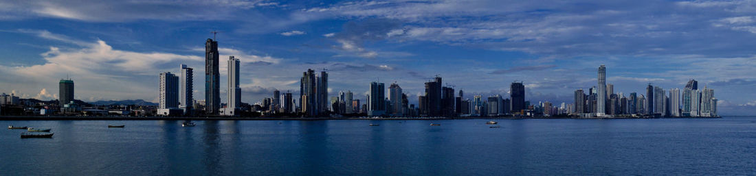 Panoramic view of sea and buildings against sky