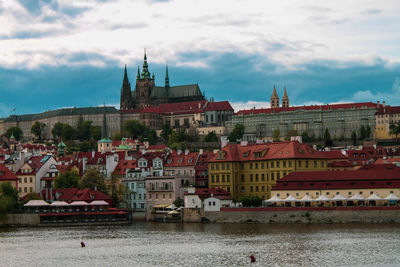 Buildings in city against cloudy sky