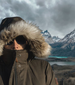 Portrait of woman with snow in mountains against sky