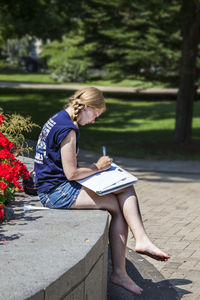 Rear view of woman sitting on bench