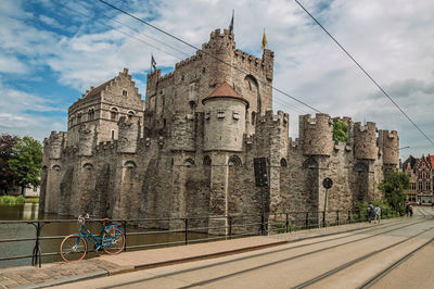 Bridge and bike in front of gravensteen castle in ghent. a city full of gothic buildings in belgium.