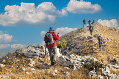 Group of hikers reach the top of the ridges of the mountains of pescasseroli, near the iorio refuge.