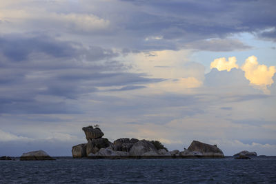 Scenic view of rocks in sea against sky