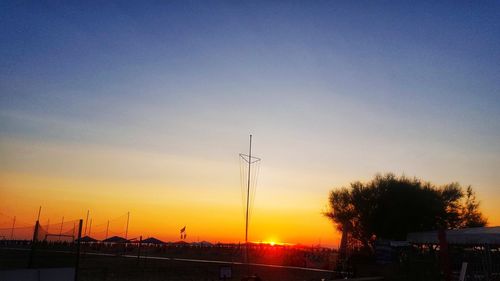 Silhouette street against sky during sunset