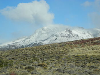 Scenic view of snow covered mountains in clouds