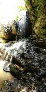 Scenic view of waterfall in forest against sky