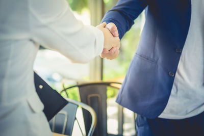 Midsection of business colleagues shaking hands