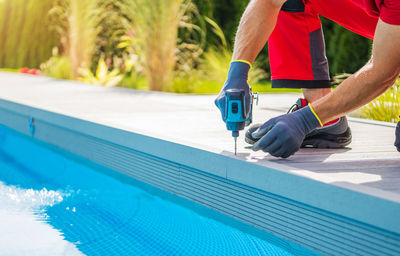 Low section of man exercising in swimming pool