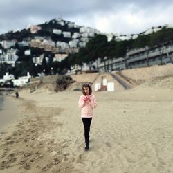 Girl on beach with camera standing on beach