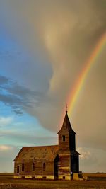 Rainbow over building against sky