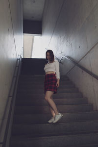 Low angle view of young woman on staircase