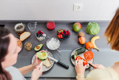 High angle view of women preparing food at kitchen