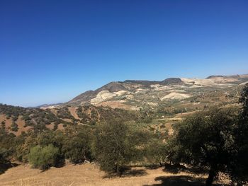 Scenic view of mountains against clear blue sky