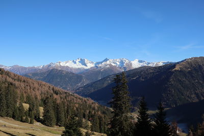 Scenic view of snowcapped mountains against blue sky