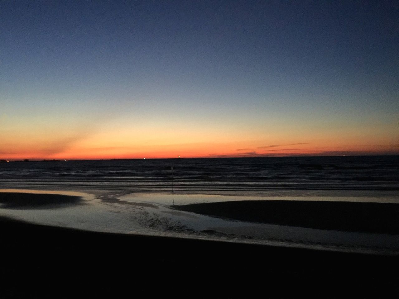 SCENIC VIEW OF BEACH AGAINST CLEAR SKY AT SUNSET