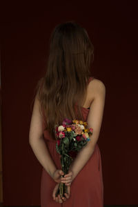 Rear view of young woman with bouquet