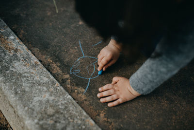 Child drawing with colored chalk on the floor