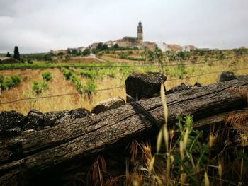 Close-up of wooden post on field against sky