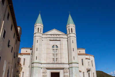 Low angle view of historic building against clear blue sky