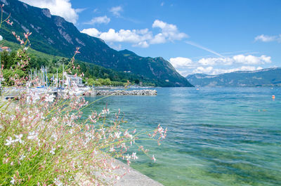 Scenic view of sea and mountains against blue sky