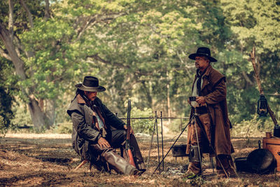 Cowboys standing in forest