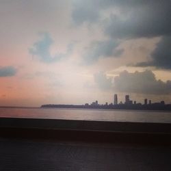 View of cityscape against cloudy sky