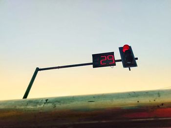Low angle view of road sign against clear sky