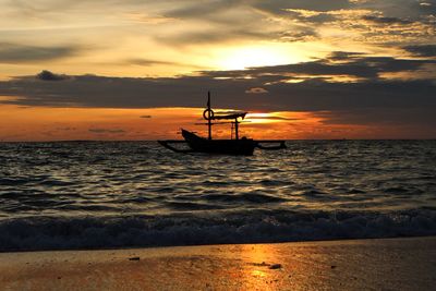 Silhouette boat in sea against sky during sunset